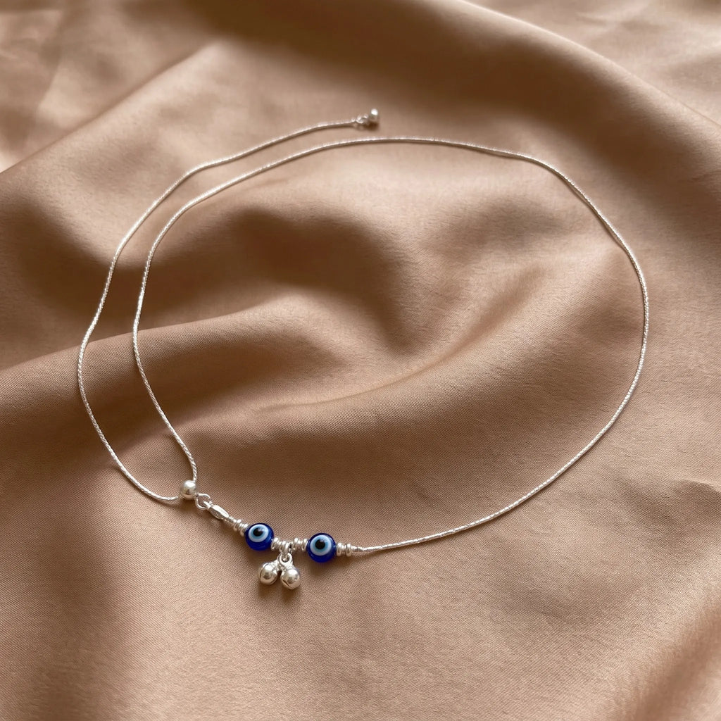 Marvel Silver Evil Eye Charm Adjustable Silver Kamarbandh Worn by Woman with Light Blue Embroidered Saree, Featuring Two Blue Evil Eye Charms and Dangling Silver Beads