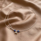 Marvel Silver Evil Eye Charm Adjustable Silver Kamarbandh Worn by Woman with Light Blue Embroidered Saree, Featuring Two Blue Evil Eye Charms and Dangling Silver Beads
