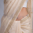 Marvel Silver Floral Charm Adjustable Silver Kamarbandh Worn by Woman with Cream and Gold Embroidered Saree Featuring Delicate Flower Charms and Polished Silver Beads