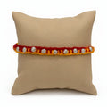 Marvel Silver floral motif yellow red rakhi with multiple silver-tone decorative charms