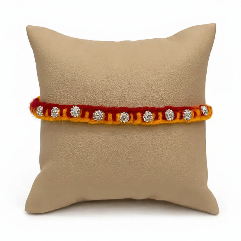 Marvel Silver floral motif yellow red rakhi with multiple silver-tone decorative charms