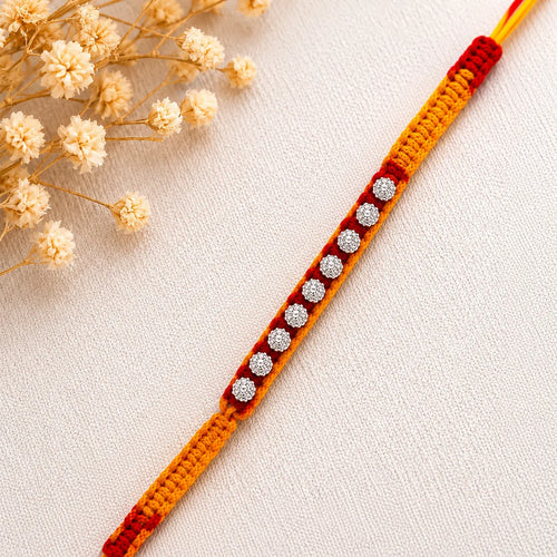 Marvel Silver floral motif yellow red rakhi with multiple silver-tone decorative charms