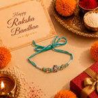 Marvel Silver Ganesh Silver Rakhi with Green Crystal Beads, White Pearl Beads, Golden Accent Beads and Red Green CZ Stones for Raksha Bandhan