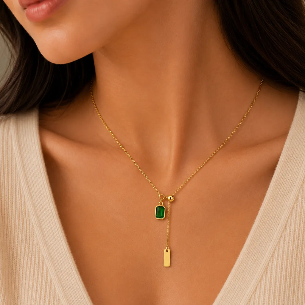 Marvel Silver gold-plated emerald green stone chain pendant for women and girls featuring an adjustable lariat chain with a rectangular green crystal charm and elegant gold bar drop.