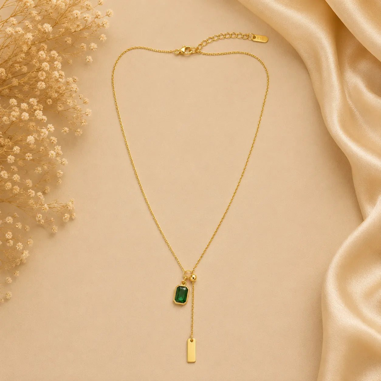 Marvel Silver gold-plated emerald green stone chain pendant for women and girls featuring an adjustable lariat chain with a rectangular green crystal charm and elegant gold bar drop.