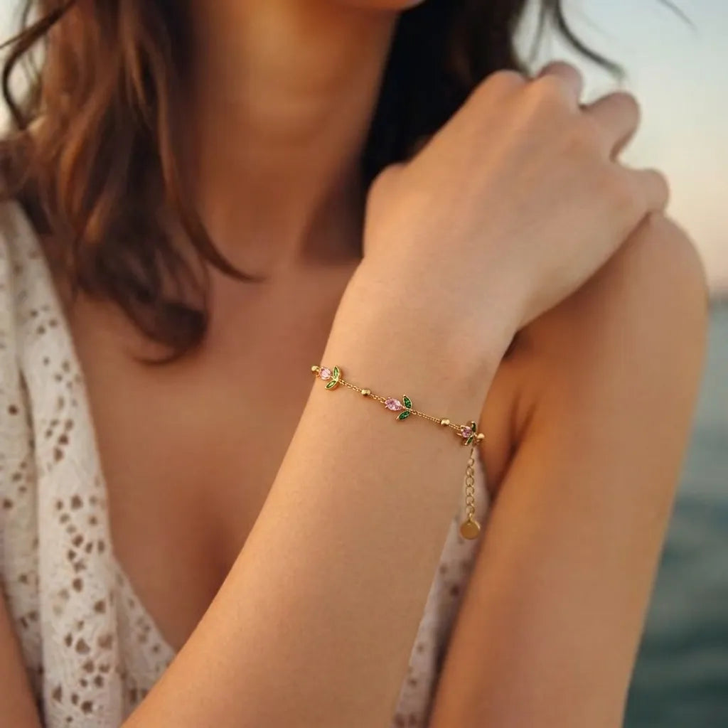 Marvel Silver gold-plated bracelet featuring delicate pink floral charms, green leaf accents, gold bead detailing, and an adjustable chain for women and girls, ideal for everyday wear, parties, weddings, festive occasions, and gifting.