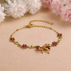 Marvel Silver gold-plated bracelet featuring a ruby-red butterfly centerpiece, floral stone charms, green leaf accents, and an adjustable extension chain for women and girls, ideal for daily wear, parties, weddings, festive occasions, and gifting.