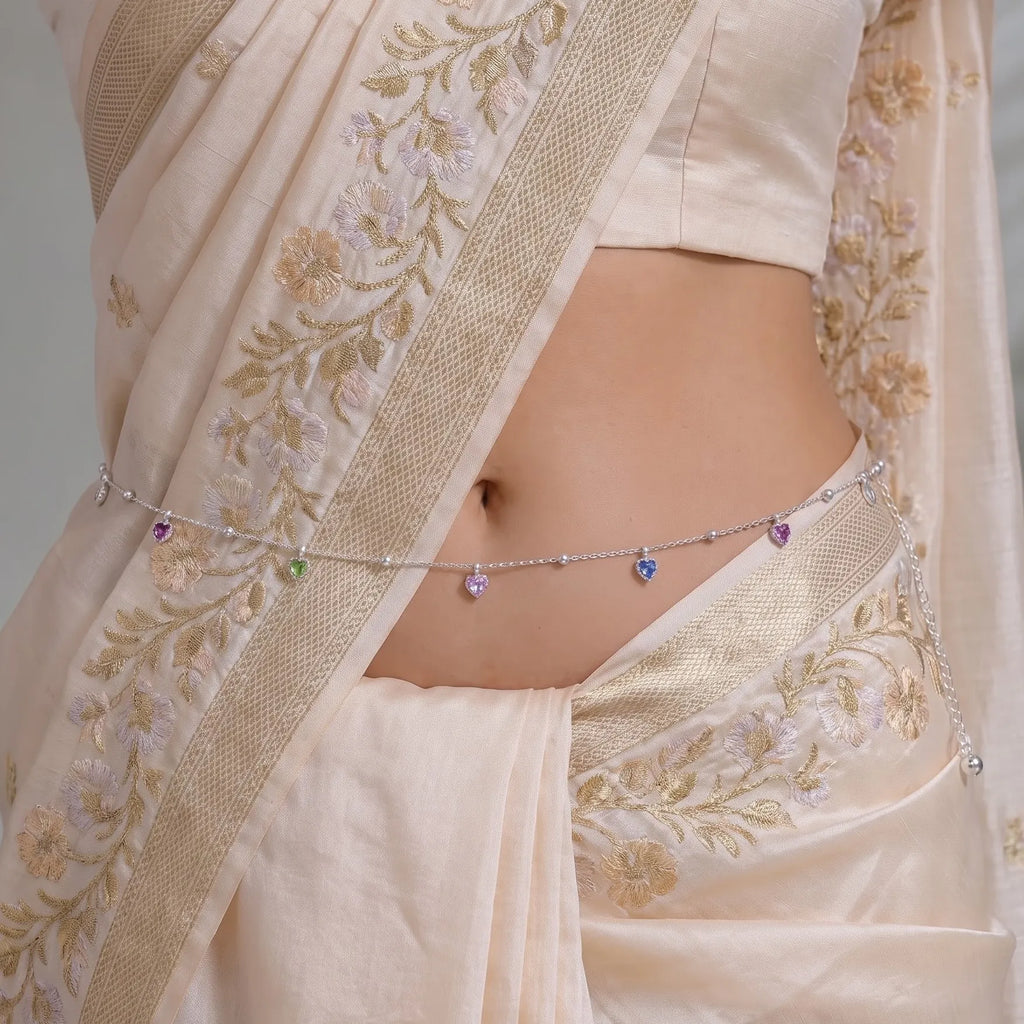 Marvel Silver Multicolor Heart Charm Silver Waist Chain Kamarband Worn by Woman with Cream Embroidered Saree, Featuring Colourful Heart-Shaped Charms and Delicate Silver Bead Detailing