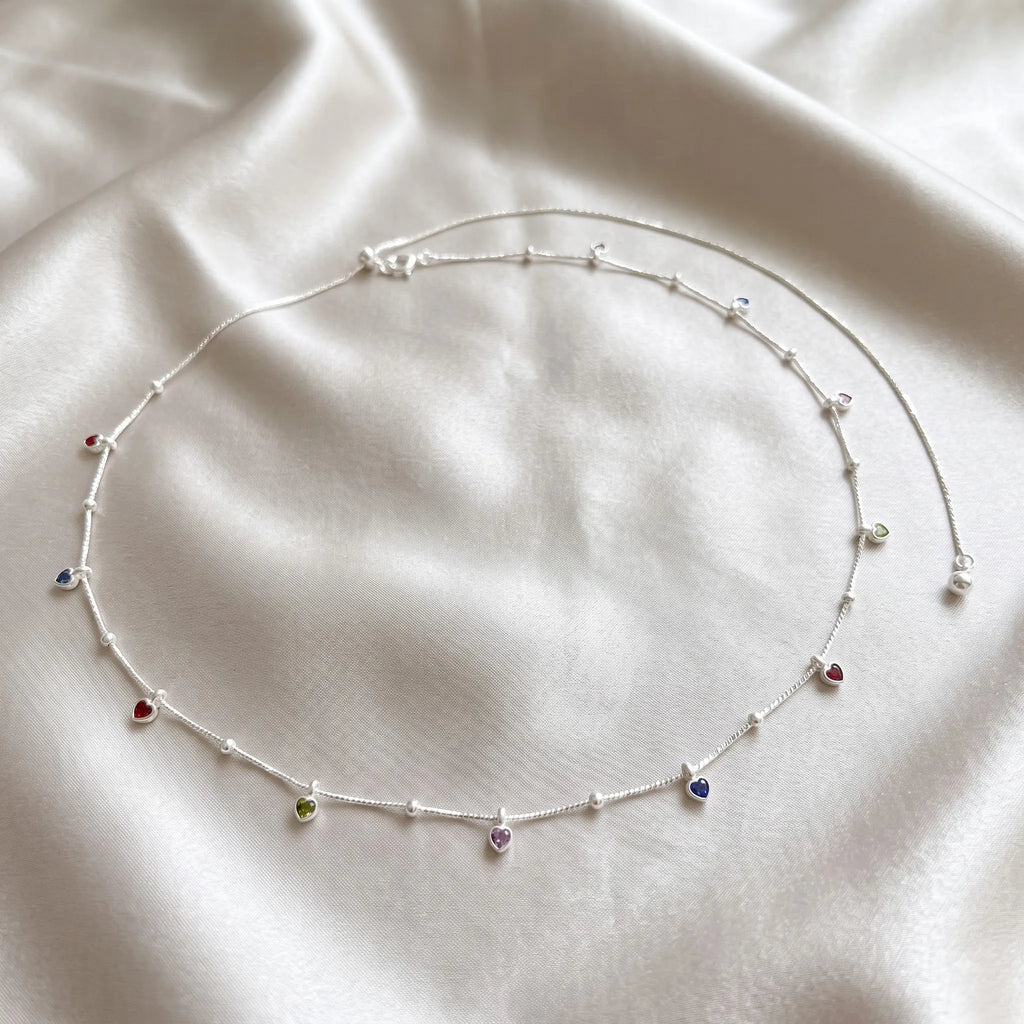 Marvel Silver Multicolor Heart Charm Silver Waist Chain Kamarband Worn by Woman with Cream Embroidered Saree, Featuring Colourful Heart-Shaped Charms and Delicate Silver Bead Detailing