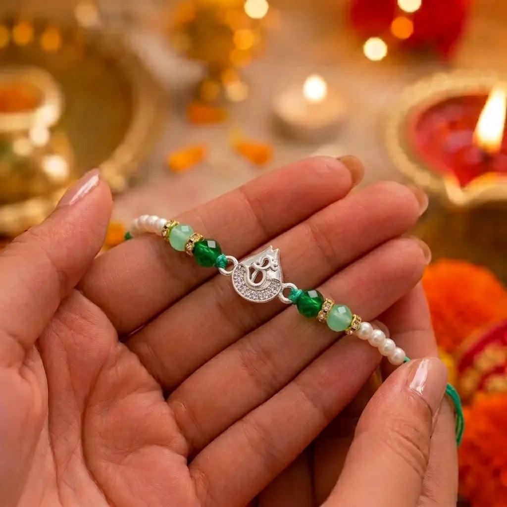 Marvel Silver Om Silver Rakhi with Green Crystal Beads, White Pearl Beads and Sparkling Om Symbol for Raksha Bandhan