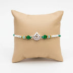 Marvel Silver Om Silver Rakhi with Green Crystal Beads, White Pearl Beads and Sparkling Om Symbol for Raksha Bandhan