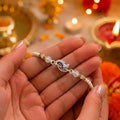 Marvel Silver Peacock Feather Silver Rakhi with Purple CZ Stones, White Crystal Beads and White Pearl Beads for Raksha Bandhan