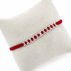 Marvel Silver red thread rakhi with polished silver-tone repeating bead cluster pattern