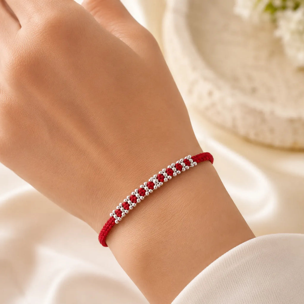 Marvel Silver red thread rakhi with polished silver-tone repeating bead cluster pattern