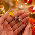 Marvel Silver Rudraksha Rakhi featuring a sacred Rudraksha bead, premium silver beads, and a traditional red-orange thread for Raksha Bandhan celebration.