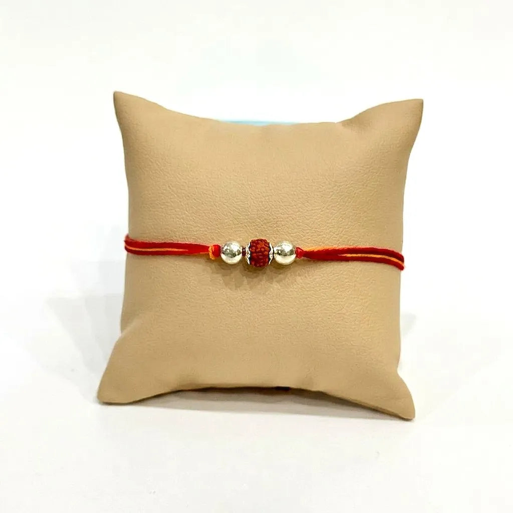 Marvel Silver Rudraksha Rakhi featuring a sacred Rudraksha bead, premium silver beads, and a traditional red-orange thread for Raksha Bandhan celebration.
