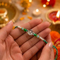 Marvel Silver Shiv Ling Silver Rakhi with Green Crystal Beads, White Pearl Beads and Sparkling Shiv Ling Charm for Raksha Bandhan