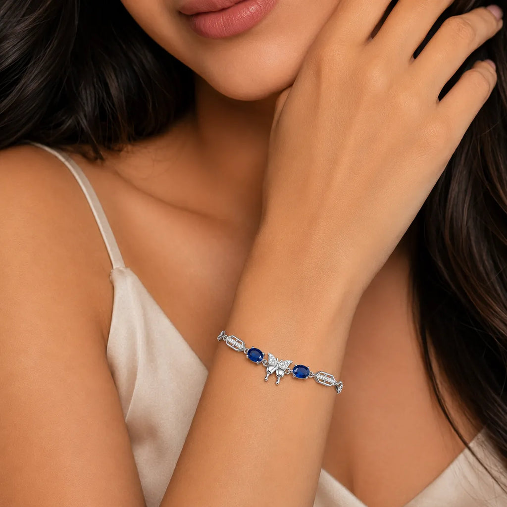 Marvel Silver 925 sterling silver bracelet featuring a sparkling butterfly centerpiece with blue gemstones, white AAA Cubic Zirconia accents, elegant heart-link chain, rhodium-plated finish, adjustable extension chain, and a stylish design for women and girls suitable for daily wear, parties, weddings, anniversaries, and gifting.