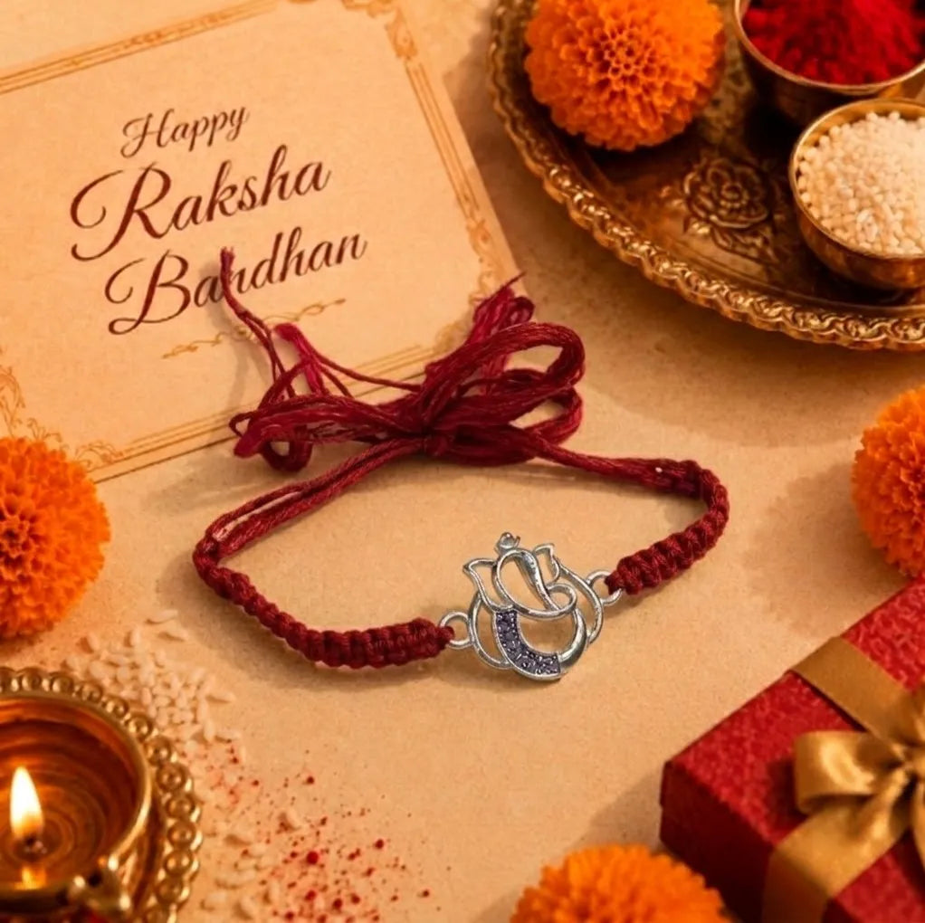 Marvel Silver Designer Ganesh Rakhi with silver-finish Lord Ganesha charm, pink braided thread, and sparkling stone detailing for Raksha Bandhan.