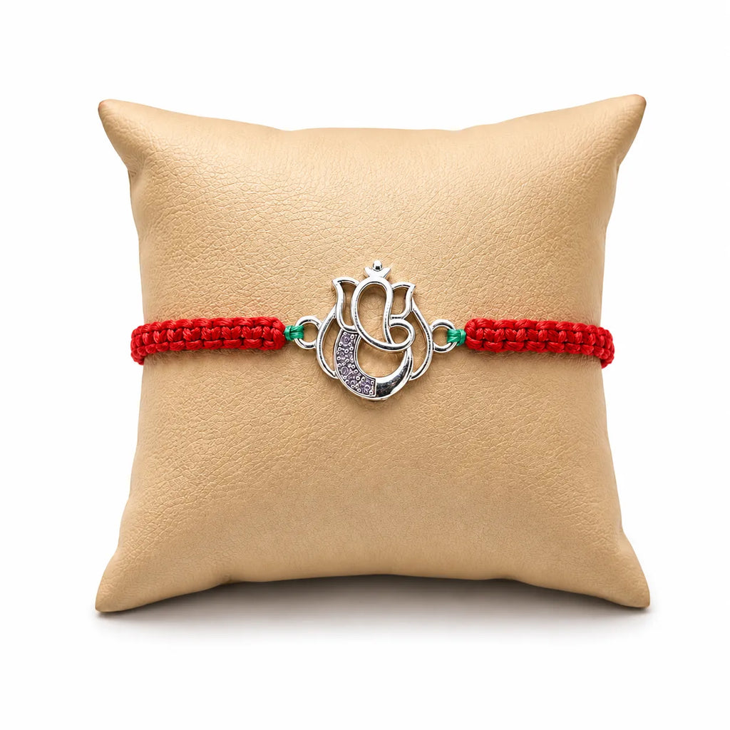 Marvel Silver Designer Ganesh Rakhi with silver-finish Lord Ganesha charm, pink braided thread, and sparkling stone detailing for Raksha Bandhan.