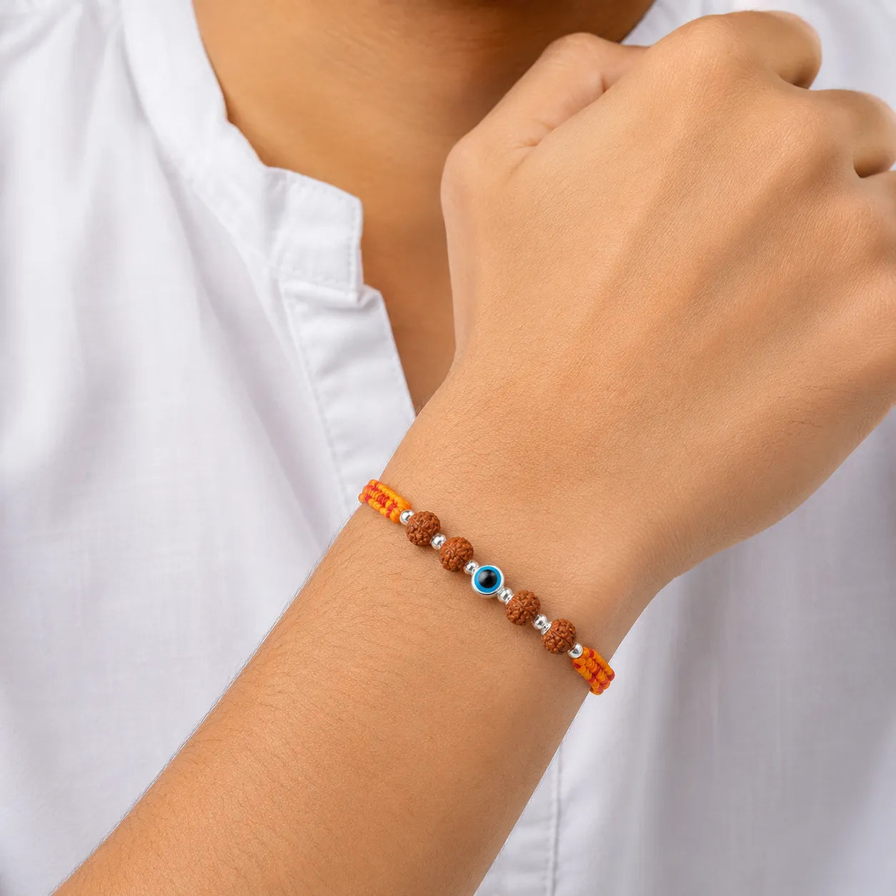 Marvel Silver Evil Eye Rudraksha Rakhi with polished silver beads on a saffron and red braided thread