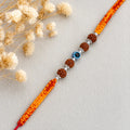 Marvel Silver Evil Eye Rudraksha Rakhi with polished silver beads on a saffron and red braided thread