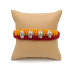 Marvel Silver Ganesh Designer Rakhi featuring four silver-finish Lord Ganesha charms on a handcrafted yellow and maroon braided thread for Raksha Bandhan.