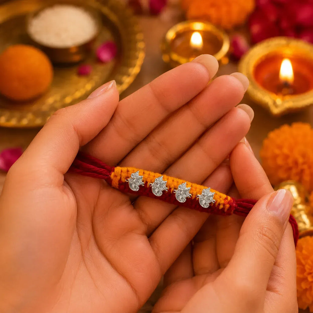 Marvel Silver Ganesh Designer Rakhi featuring four silver-finish Lord Ganesha charms on a handcrafted yellow and maroon braided thread for Raksha Bandhan.