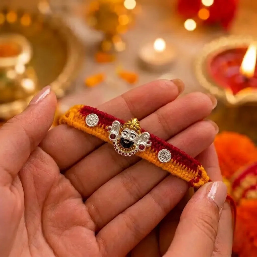 Marvel Silver Khatu Shyam Ji silver rakhi with premium designer silver charm, sparkling stone accents, and handcrafted red and yellow cotton thread for Raksha Bandhan.