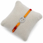 Marvel Silver Krishna name rakhi for brother with yellow red braided thread and silver-tone circular stone-style charm