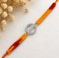 Marvel Silver Krishna name rakhi for brother with yellow red braided thread and silver-tone circular stone-style charm