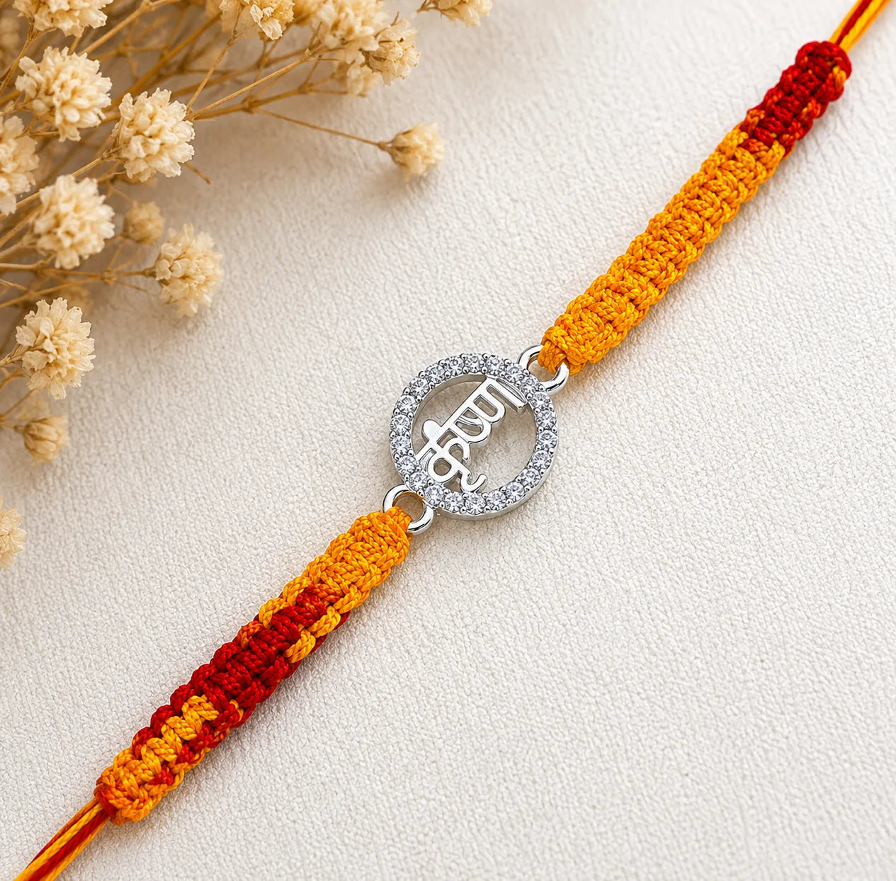 Marvel Silver Krishna name rakhi for brother with yellow red braided thread and silver-tone circular stone-style charm