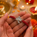 Marvel Silver Lord Ganesha Rakhi featuring a silver-finish Ganesh charm on a handcrafted red braided thread for Raksha Bandhan.