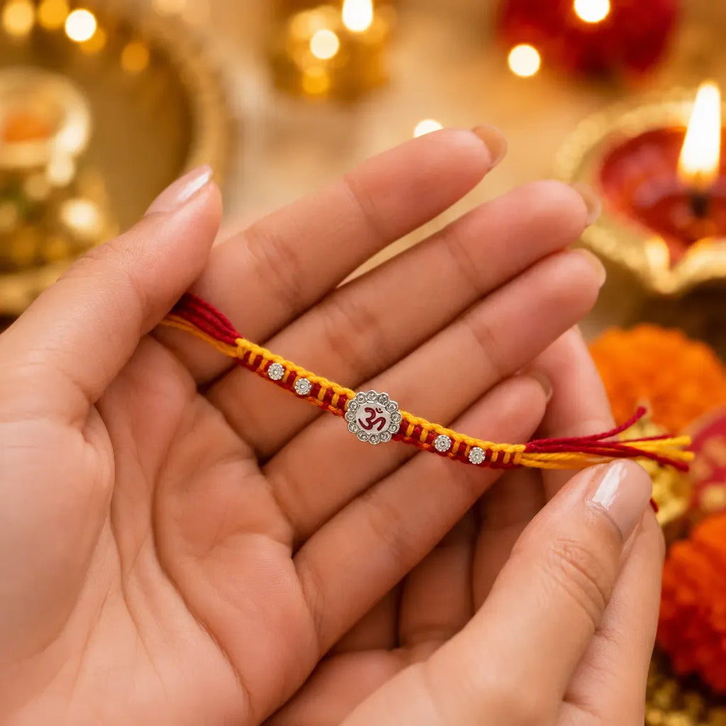 Marvel Silver Om Designer Rakhi with sparkling Om centerpiece, silver decorative beads, and red-yellow braided thread for Raksha Bandhan