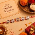 Marvel Silver Om & Lord Ganesha Designer Rakhi with stone-studded charms and handcrafted yellow maroon braided thread for Raksha Bandhan celebration.