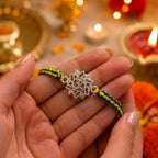 Marvel Silver Om Lotus Rakhi with silver finish Om symbol and blue yellow handcrafted thread for Raksha Bandhan.