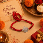 Marvel Silver Om Lotus Rakhi with silver finish Om symbol and blue yellow handcrafted thread for Raksha Bandhan.