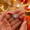 Marvel Silver Om Rakhi featuring a silver-finish Om symbol charm on a handcrafted red thread for Raksha Bandhan celebrations.