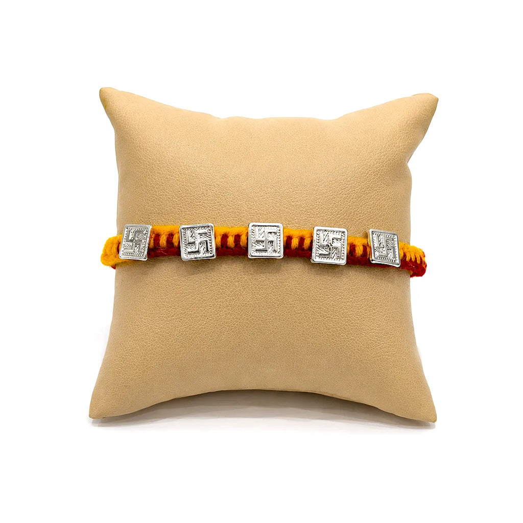 Marvel Silver handcrafted Om & Swastik designer Rakhi with traditional red and yellow braided thread for Raksha Bandhan.