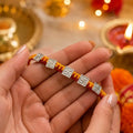 Marvel Silver handcrafted Om & Swastik designer Rakhi with traditional red and yellow braided thread for Raksha Bandhan.