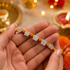 Marvel Silver handcrafted Om & Swastik designer Rakhi with traditional red and yellow braided thread for Raksha Bandhan.