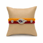 Marvel Silver designer silver peacock feather rakhi with red stone centerpiece and handcrafted yellow and red cotton thread for Raksha Bandhan.