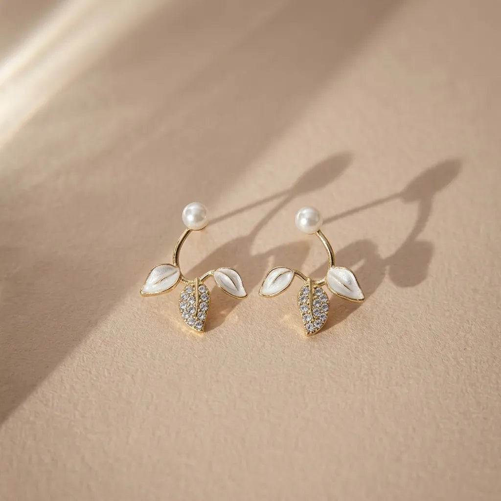 Marvel Silver pearl leaf designer imitation stud earrings with CZ stones, enamel leaves, and premium gold-plated finish for women.