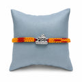 Marvel Silver Radha name rakhi for brother with yellow red braided thread and stone-studded silver-tone centre