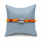 Marvel Silver Radha name rakhi for brother with yellow red braided thread and stone-studded silver-tone centre
