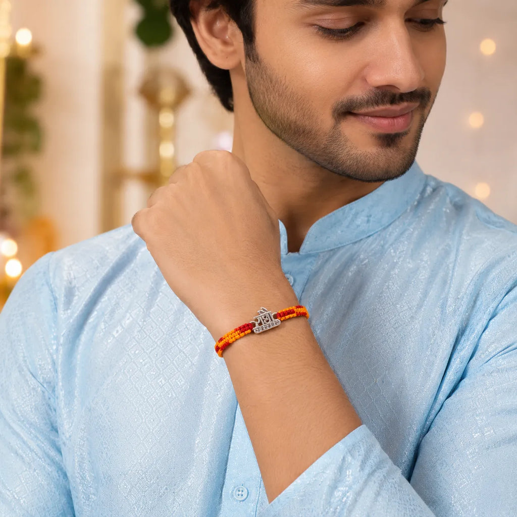 Marvel Silver Radha name rakhi for brother with yellow red braided thread and stone-studded silver-tone centre