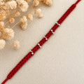 Marvel Silver red thread minimal rakhi with polished silver-tone bead cluster detailing