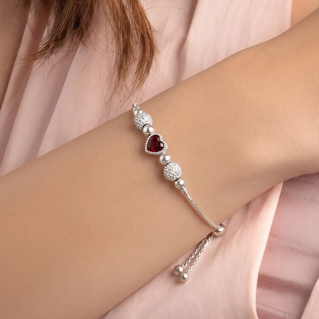 Marvel Silver Ruby Heart Bracelet with adjustable silver chain, ruby red heart crystal, polished silver beads, and sparkling crystal ball accents for women and girls.