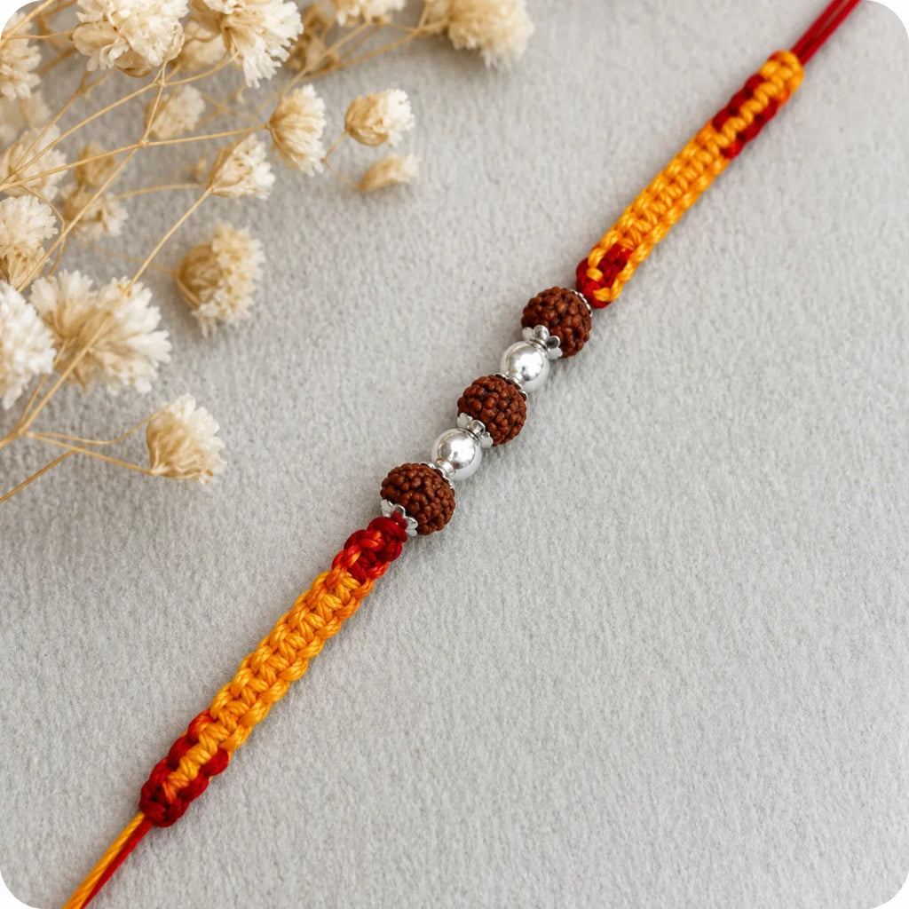 Marvel Silver Rudraksha bead rakhi with polished silver beads on a saffron and red braided thread
