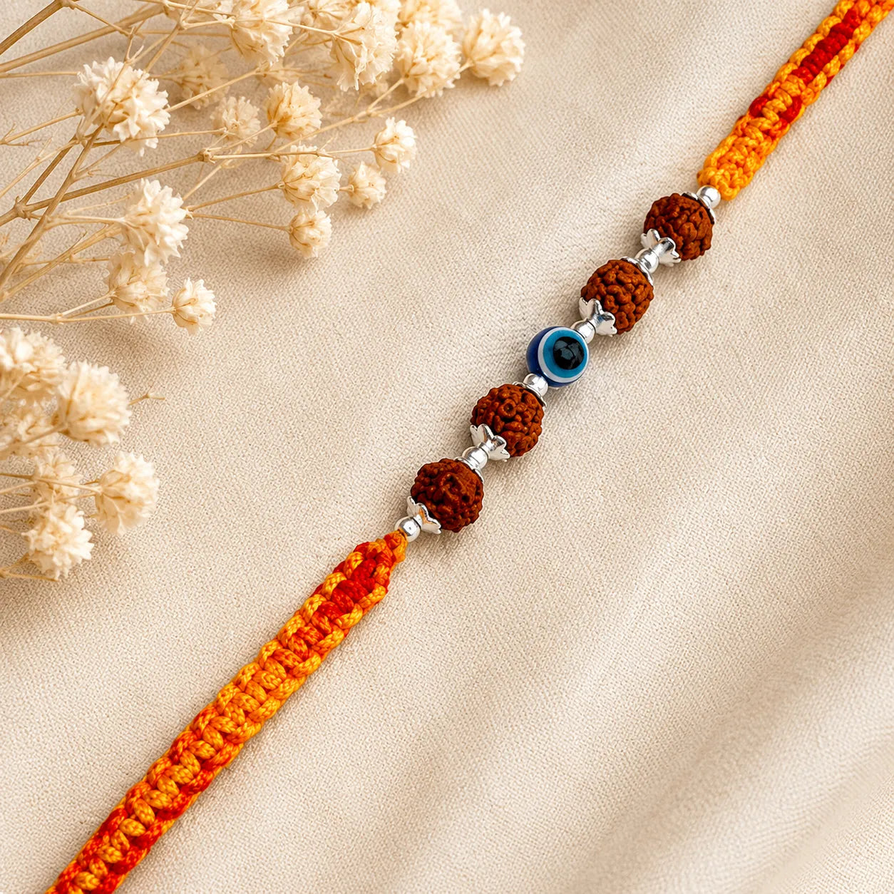 Marvel Silver Rudraksha evil eye rakhi for brother with yellow red braided thread and silver-tone bead accents
